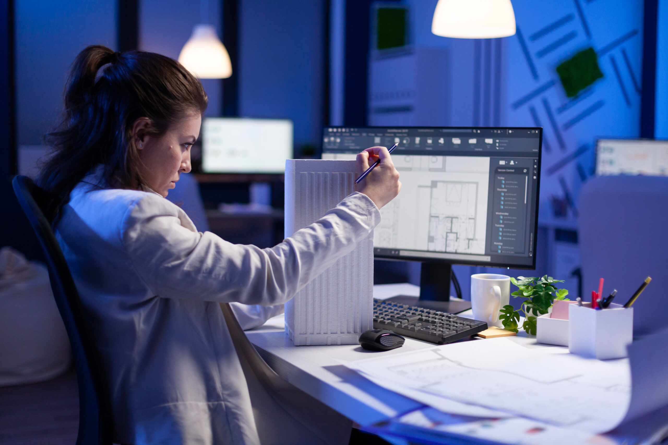 Woman architect analysing and matching blueprints for new building project